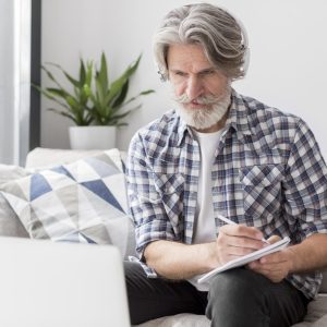 teacher-looking-laptop-writing-down